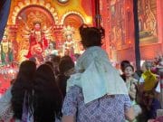 A Father’s Shoulders Offer a Child a Better View of Durga Puja